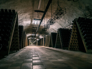 Vast underground wine cellar showcasing rows of bottles in a dimly lit tunnel