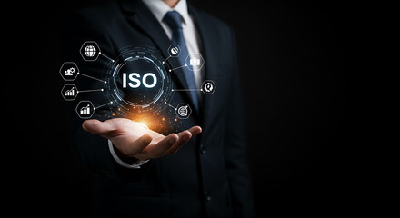 Naklejka premium Man in suit holding iso graphic with icons representing global standards and business processes