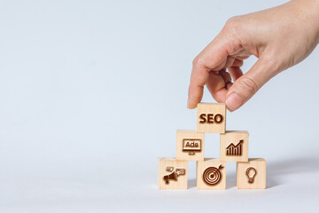 Hand placing last SEO block on top of digital marketing icon pyramid