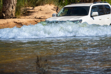 Obraz premium 4x4 vehicle driving through or across riveron expedition in Western Australian outback