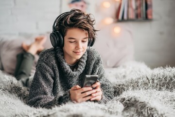 Relaxed Teen Listening to Music on Smartphone in Cozy Bedroom Setting with Warm Ambient Lighting