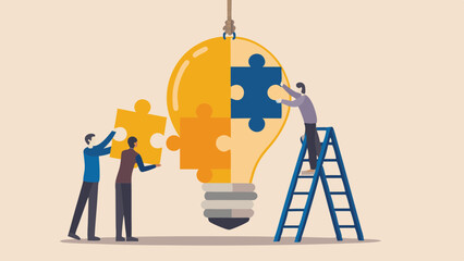 Teamwork assembling a lightbulb made of puzzle pieces symbolizing a shared idea
