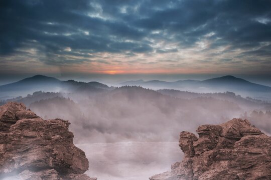Fototapeta Mist filled mountain valley is being shown in flat design, featuring rugged cliffs and cloudy sky
