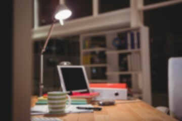 Defocused image of digital tablet and files by lamp