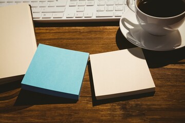Keyboard and coffee cup on table with book