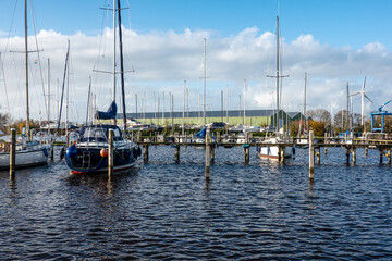 Sailboats mooring in a harbor during a sunny day with blue sky and clouds
