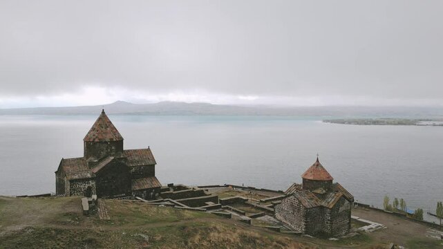 Aerial rising view Sevanavank monastic complex. Peninsula at the northwestern shore of Lake Sevan in the Gegharkunik Province of Armenia. Popular travel sightseeing attraction
