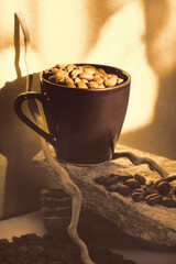 Freshly harvested coffee beans and cup of coffee, stone podium. Still life. Soft sunset light, twilight. Atmosperic mood