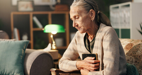 Sad, old woman and thinking with picture frame in home for mourning, grief and lonely in...