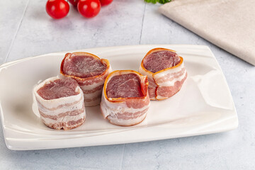 Raw pork tenferloin with bacon