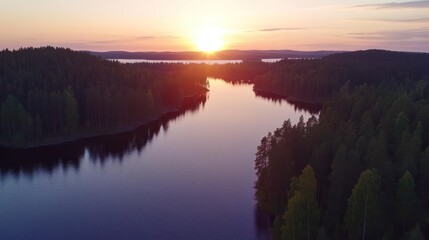 Obraz premium Sunset over a serene Finnish lake, surrounded by lush forests. Breathtaking aerial view of the tranquil landscape. Picturesque scenery.