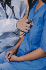 A doctor uses a stethoscope to check the heartbeat of his patient. Patients must undergo a yearly...