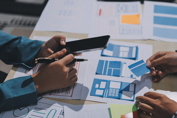 Group of young application developers analyzing uxui mobile app templates during a working meeting