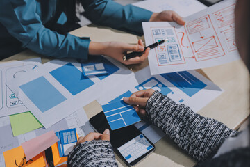 Group of young application developers analyzing uxui mobile app templates during a working meeting