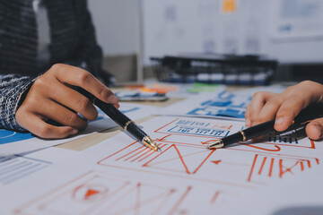 Group of young application developers analyzing uxui mobile app templates during a working meeting