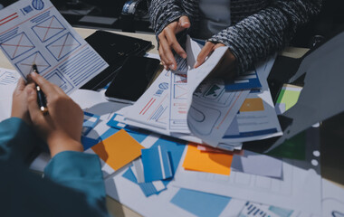 Group of young application developers analyzing uxui mobile app templates during a working meeting
