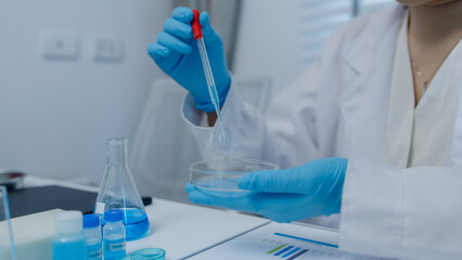 a female chemist is testing various liquid compounds in a lab, a scientist is doing research on the...