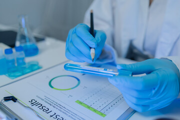 a female chemist is testing various liquid compounds in a lab, a scientist is doing research on the...