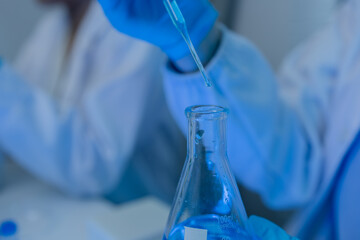 when in a lab, scientists wear lab coats, rubber gloves, and safety goggles, two chemists are testing chemicals in a liquid state, chemists working in a laboratory