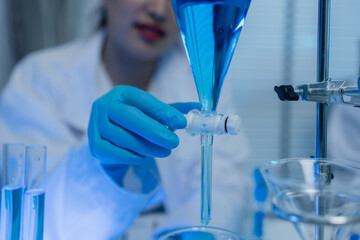 a female chemist is testing various liquid compounds in a lab, a scientist is doing research on the...