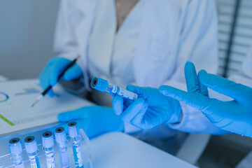 two scientists consult each other while conducting an experiment on a liquid substance in a...