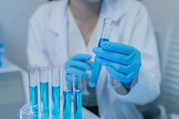 a female chemist is testing various liquid compounds in a lab, a scientist is doing research on the...