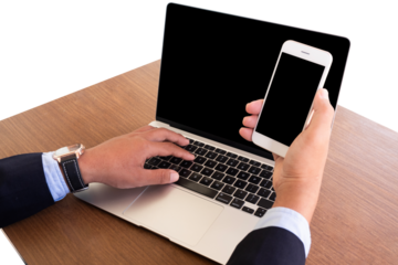 businessman using laptop and holding mobile phone