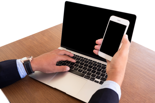 businessman using laptop and holding mobile phone