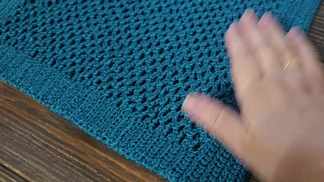 Steam treatment of a crochet bag made of green threads. Bag on a wooden background. Handmade