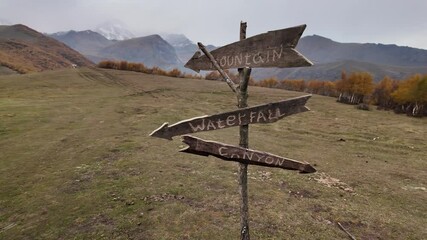 Wooden direction signpost in mountain valley. - Powered by Adobe