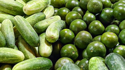Fresh produce assortment showcasing vibrant green cucumbers and limes 