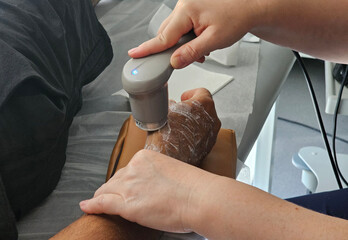 Medical professional performing ultrasound therapy on a patient arm