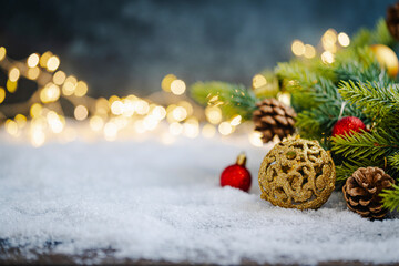 Christmas Holiday background with snow, fir tree and decorations with christmas light behind....