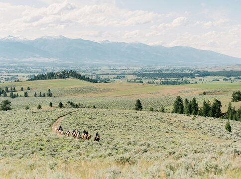 Horseback riders trail through open Montana grasslands