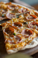Close up of pepperoni pizza on wooden serving board