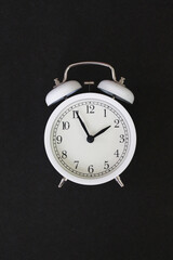 Classic White Alarm Clock Isolated Against a Black Background