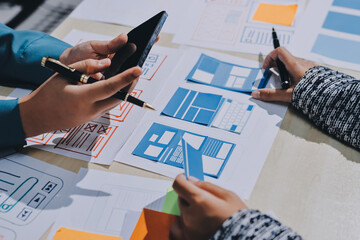 Group of young application developers analyzing uxui mobile app templates during a working meeting