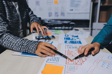 Group of young application developers analyzing uxui mobile app templates during a working meeting