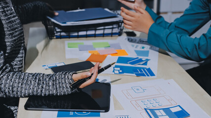 Group of young application developers analyzing uxui mobile app templates during a working meeting