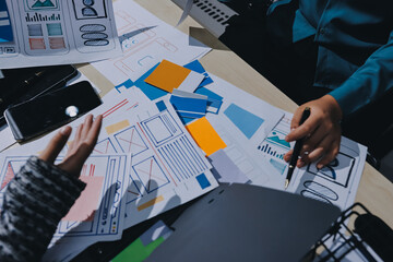 Group of young application developers analyzing uxui mobile app templates during a working meeting