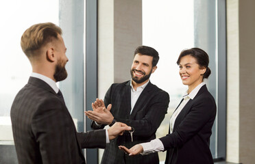 Real estate agent or broker gives keys to excited business couple, happy to rent new office, buy...