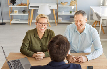 Smiling happy elderly couple talking with man advisor about health insurance or investments sitting...