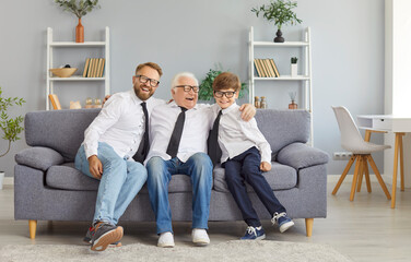 Happy father, son and grandfather wearing white shirts and black neckties for special occasion...