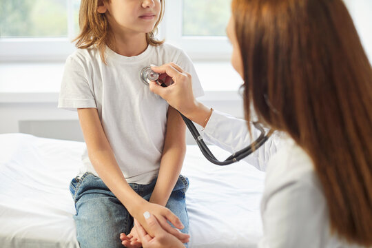 Pediatrician doctor stethoscope listening to kid heart, lung, child health care, clinic checking up exam, kid patient sitting on coach, healthcare hospital professional controlling physical well-being - Powered by Adobe