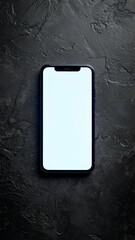 A smartphone with a blank screen sits on a dark textured surface.