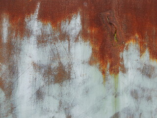 rusty metal background with white paint smears on orange sheet, traces of iron oxidation on solid...
