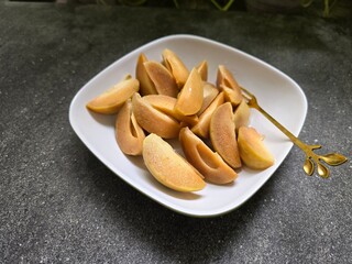 slice of sapodilla fruit in a plate 