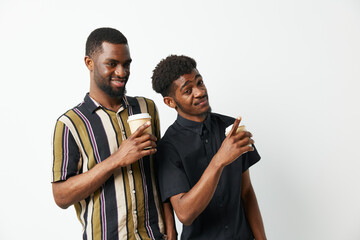 Two black men enjoying coffee together, sharing smiles and laughter in a bright, vibrant setting, capturing the essence of friendship and joy.