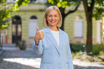 Happy smiling mature Caucasian blonde businesswoman lady female woman in formal suit looking camera...