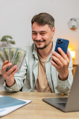 Planning family budget. Smiling Caucasian man counting money dollar cash use smartphone calculate...